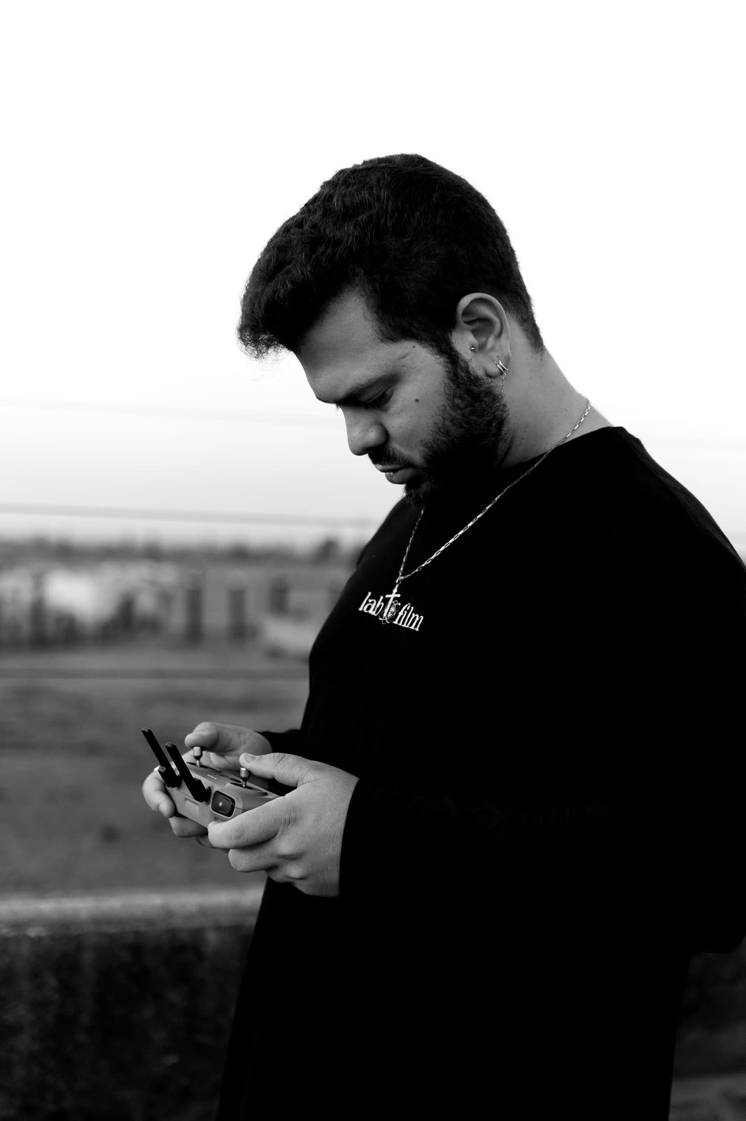 Gustavo no set, no Pará, olhando o controle do drone